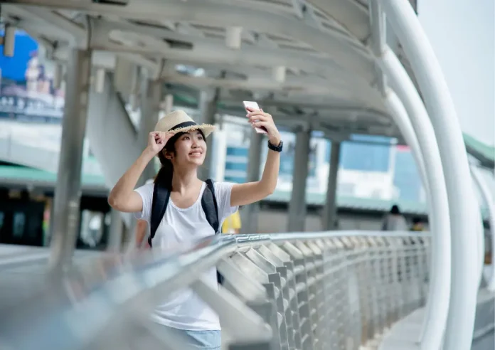 Image by Freepik | Asian traveler capturing the moment.