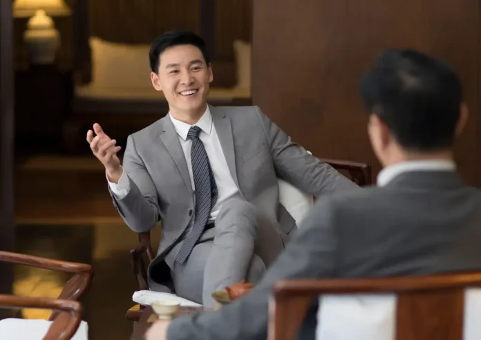 Image by Canva | Asian hotel executives discussing hotel revenue growth strategy in hotel lobby.